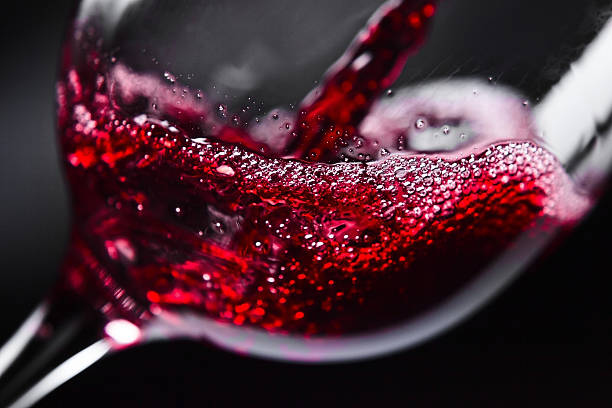 red wine in wineglass on black background